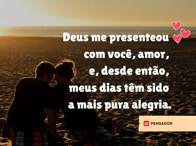 Casal se olhando sentado na areia da praia.