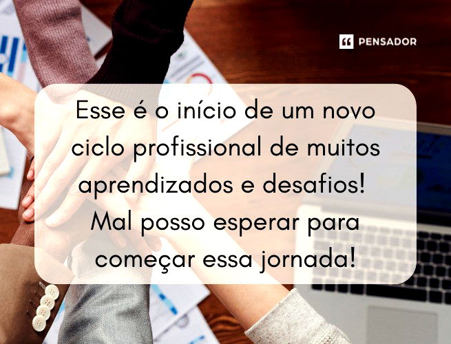 Mãos unidas, uma em cima da outra, ao lado de um notebook e em cima de uma mesa com relatórios.