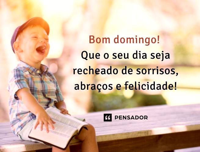 Menino gargalhando com um livro na mão.