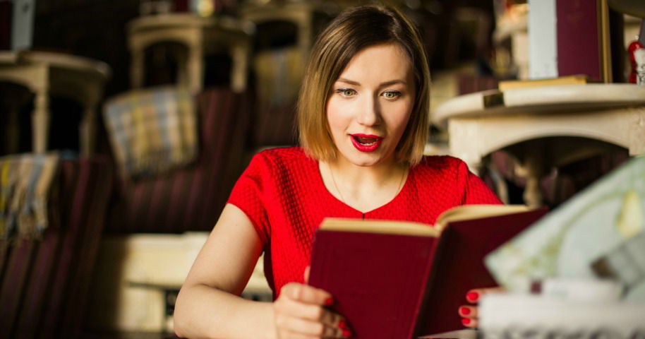 Pilha de livros inspiradores sobre uma mesa de madeira com luz natural