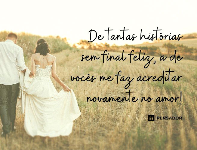 Noiva e noivo andando num campo gramado.